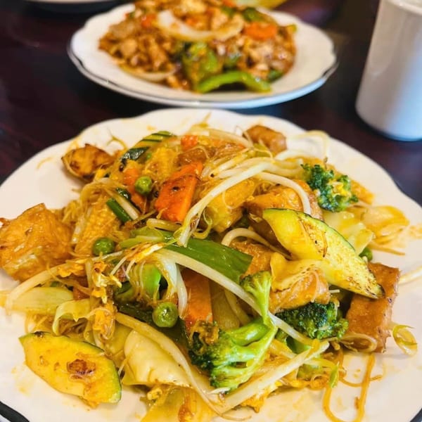 A vibrant Thai stir-fry with noodles, tofu, and colorful vegetables like broccoli, carrots, and zucchini.